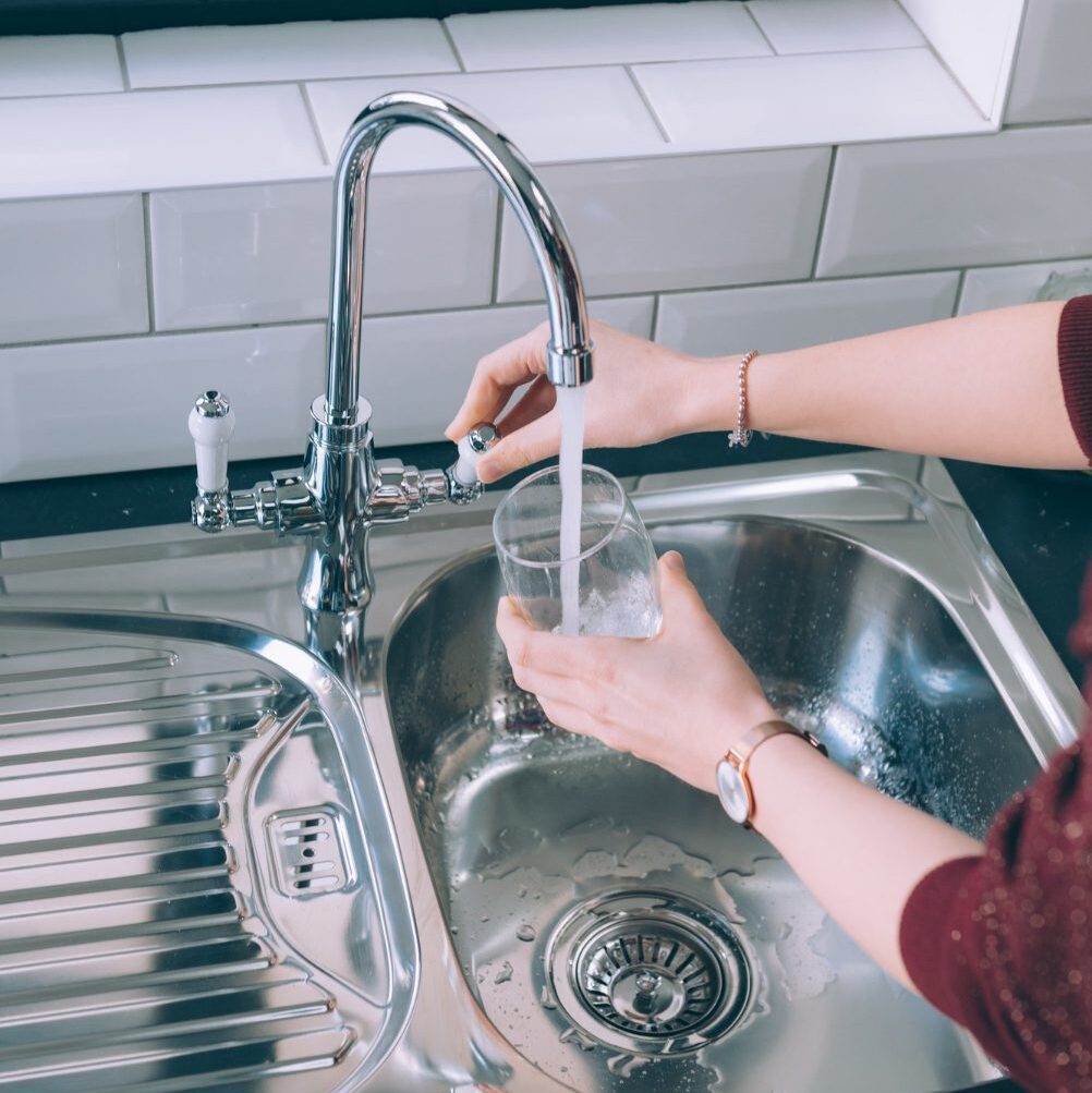 woman-filling-glass-with-water-from-steel-faucet-kitchen woman-filling-glass-with-water-from-steel-faucet-kitchen